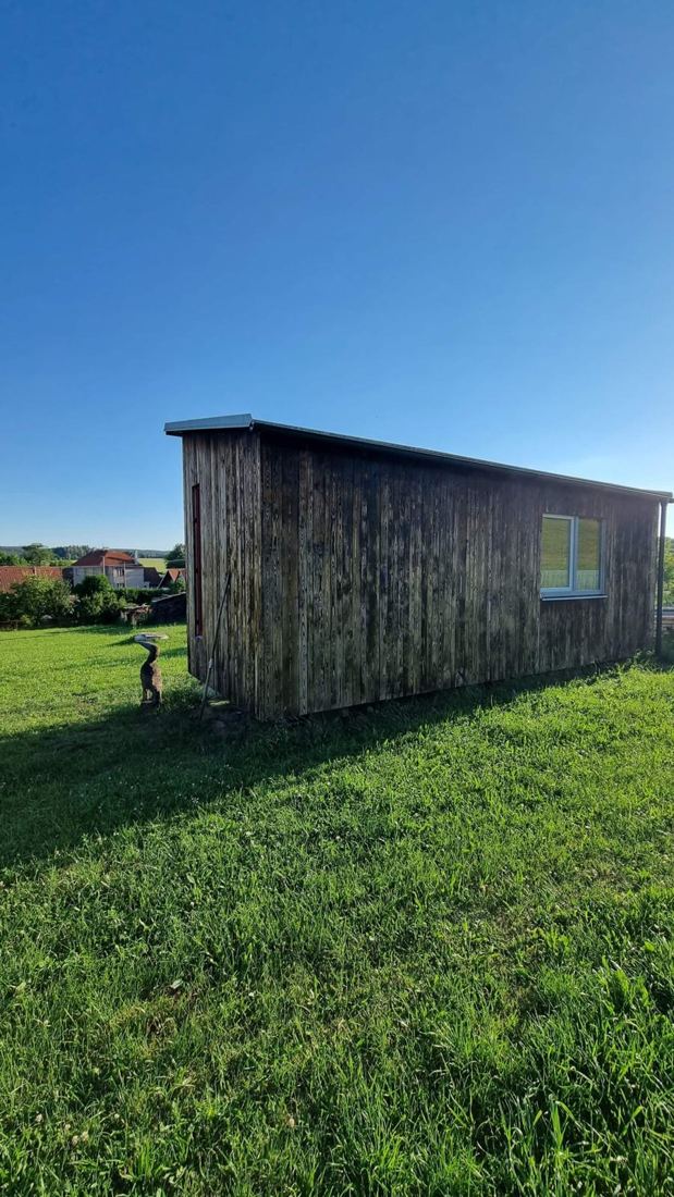 Dřevěná maringotka z boku na posečené trávě